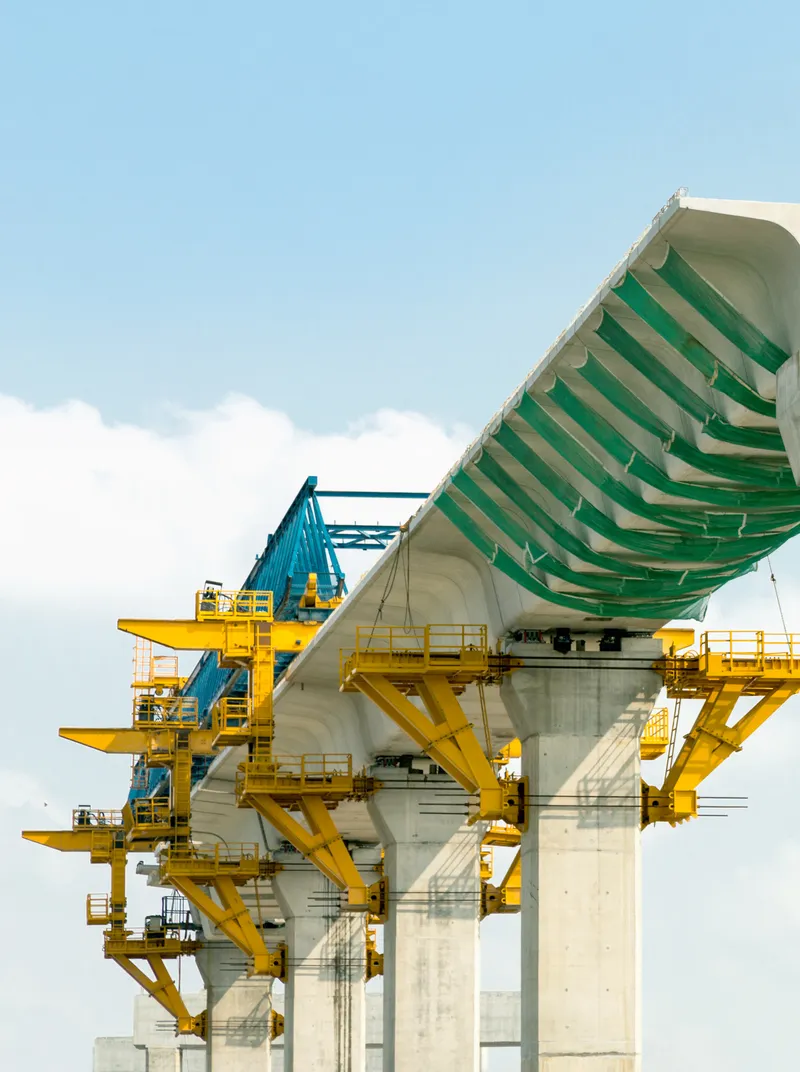 Bridge girder launch with yellow gantry over concrete piers
