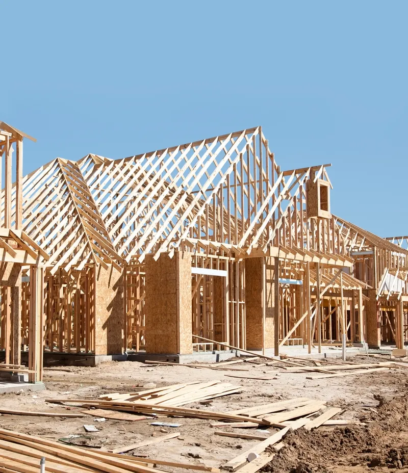Residential framing with roof trusses under blue sky